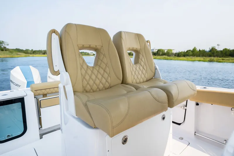 Slide: The Image of 2024 Sportsman Open 262 Center Console boat with luxurious tan seating by the water. - 17
