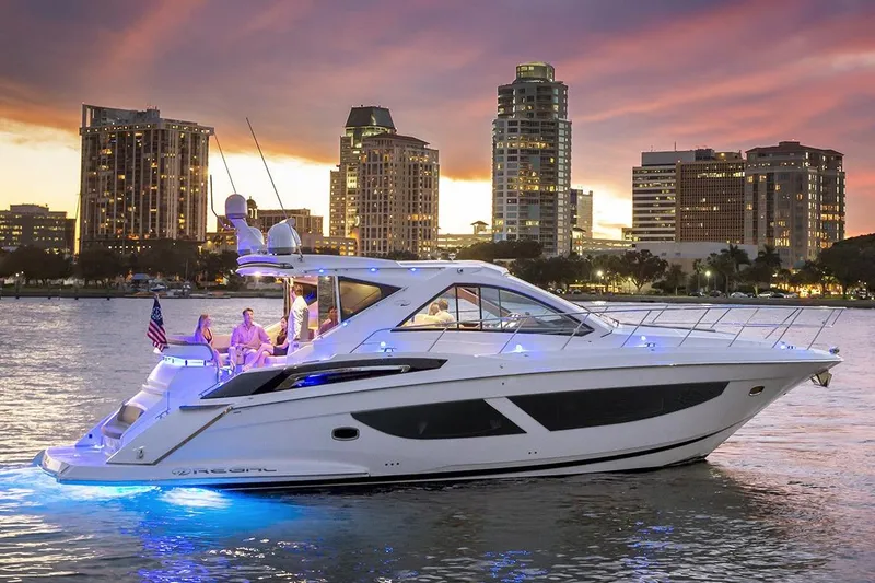 Slide: The Image of Manufacturer Provided Image: 2018 Regal 53 Sport Coupe yacht cruising at sunset with city skyline backdrop. - 1
