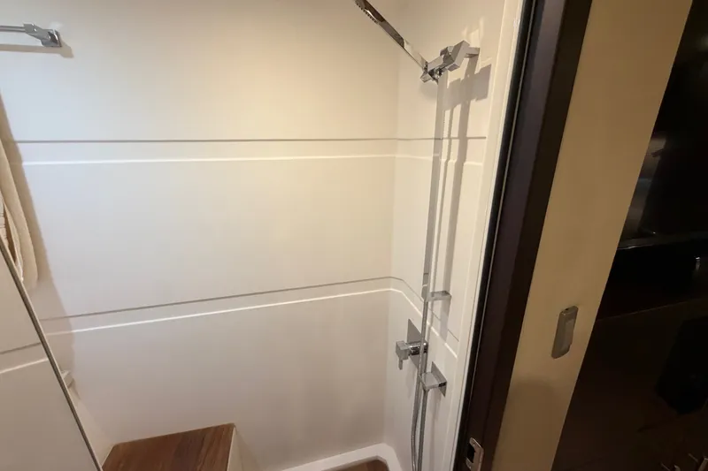 Slide: The Image of Shower area in 2018 Regal 53 Sport Coupe yacht, featuring modern fixtures and wooden accents. - 106