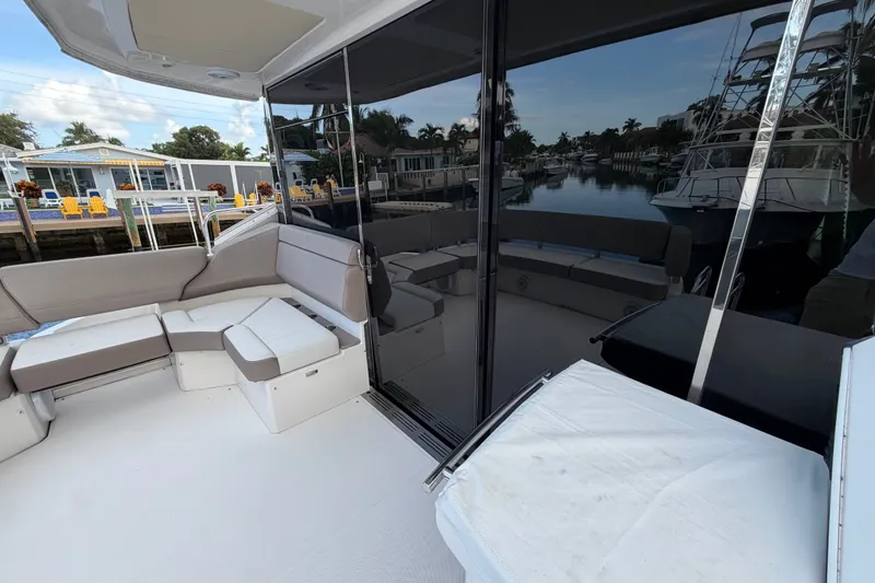 Slide: The Image of 2018 Regal 53 Sport Coupe yacht with spacious seating and waterfront view. - 66