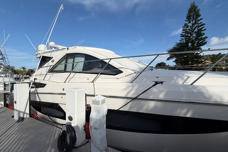 Slide: The Image of 2018 Regal 53 Sport Coupe yacht docked under clear blue sky. - 16