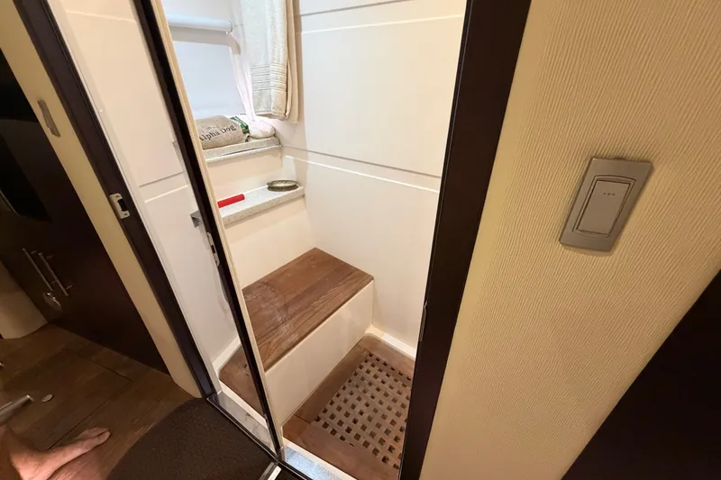 Slide: The Image of Interior of 2018 Regal 53 Sport Coupe, featuring a compact wooden step and shower area. - 105