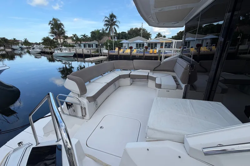 Slide: The Image of Luxurious 2018 Regal 53 Sport Coupe yacht with spacious seating, docked in a serene marina. - 27