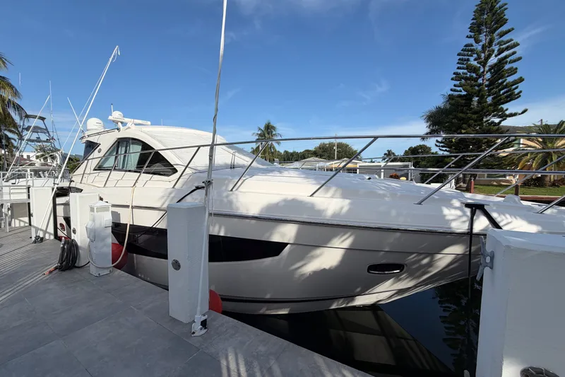 Slide: The Image of 2018 Regal 53 Sport Coupe yacht docked, surrounded by palm trees and clear blue sky. - 17