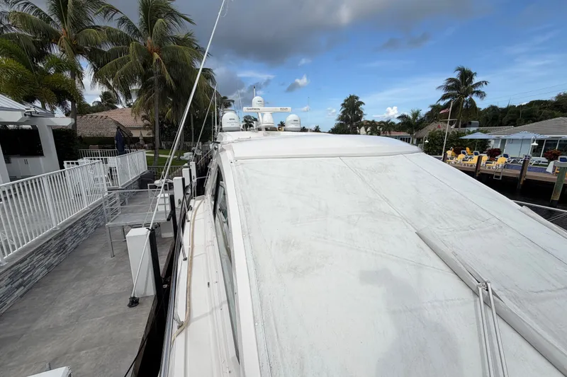 Slide: The Image of 2018 Regal 53 Sport Coupe yacht docked near palm trees and waterfront homes. - 47