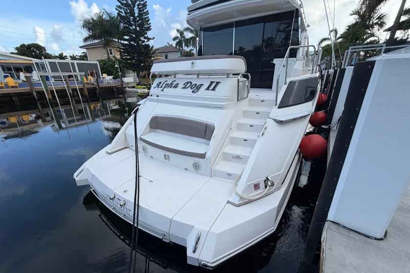 Slide: The Image of 2018 Regal 53 Sport Coupe yacht docked, rear view with "Alpha Dog II" name visible. - 10