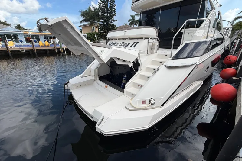 Slide: The Image of 2018 Regal 53 Sport Coupe yacht docked, open hatch, sunny day, waterfront view. - 49