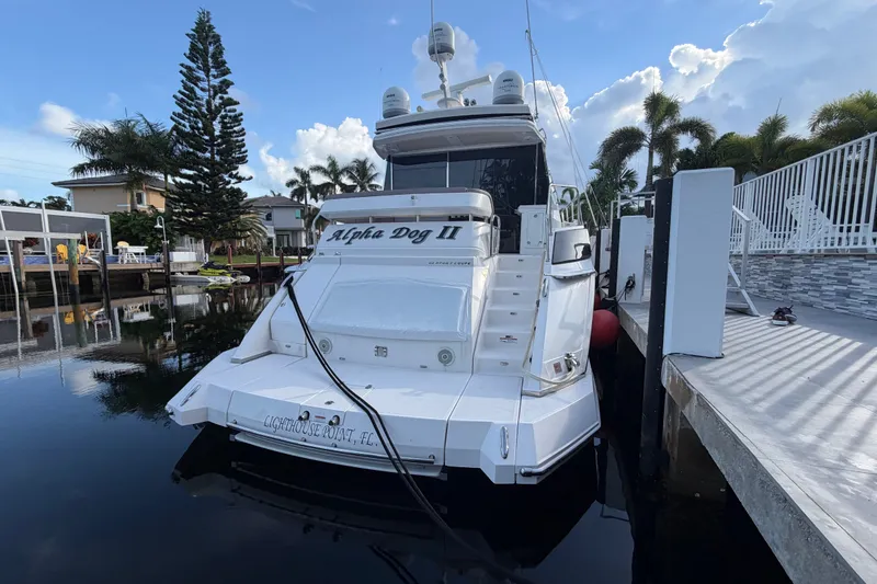 Slide: The Image of 2018 Regal 53 Sport Coupe yacht docked in a serene marina setting. - 12