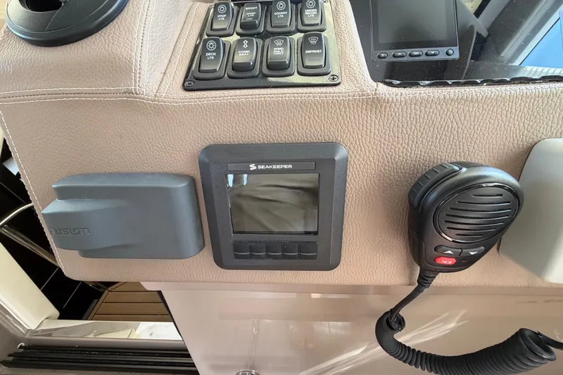 Slide: The Image of Control panel of a 2018 Regal 53 Sport Coupe with Seakeeper display and microphone. - 74
