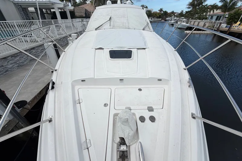 Slide: The Image of 2018 Regal 53 Sport Coupe yacht docked by a canal, showcasing sleek design and spacious deck. - 46
