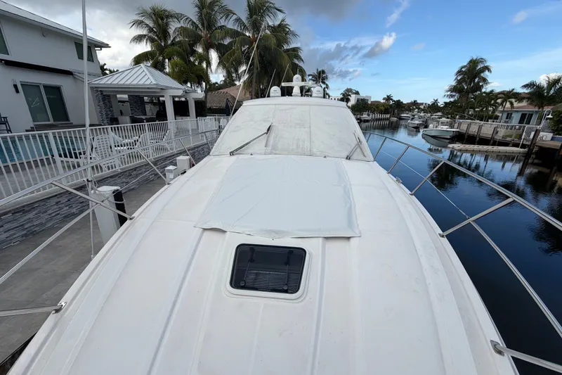 Slide: The Image of 2018 Regal 53 Sport Coupe yacht docked by waterfront homes and palm trees. - 41