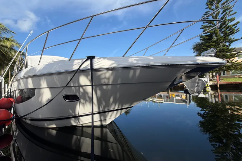 Slide: The Image of 2018 Regal 53 Sport Coupe yacht docked, reflecting on calm water under blue sky. - 21