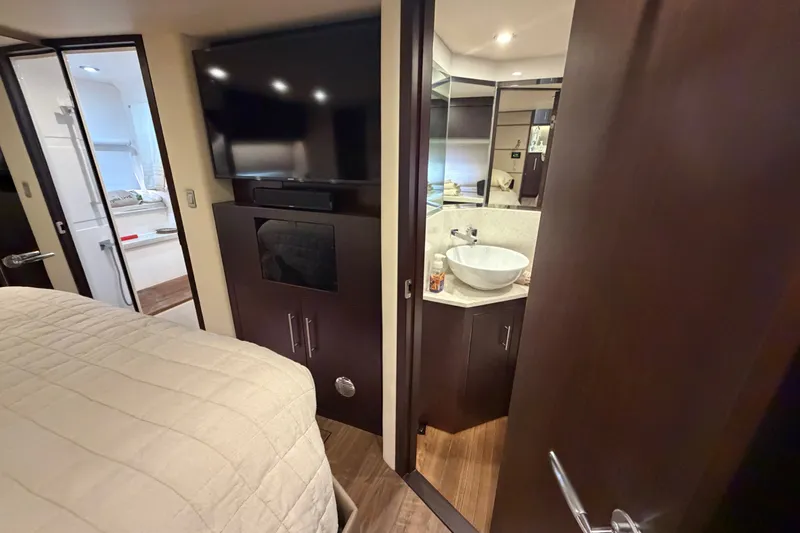 Slide: The Image of Interior of 2018 Regal 53 Sport Coupe with bedroom, TV, and bathroom sink. - 101
