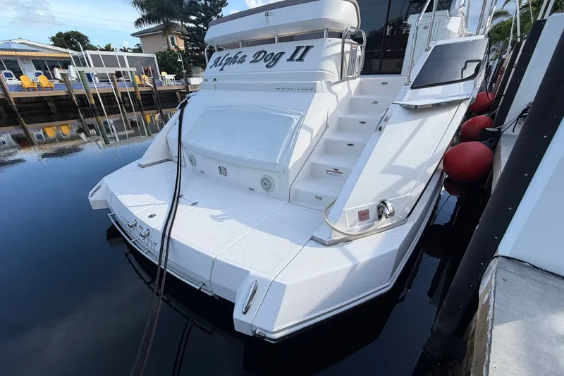 Slide: The Image of 2018 Regal 53 Sport Coupe yacht docked, featuring sleek design and spacious deck area. - 13