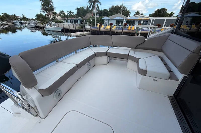 Slide: The Image of Luxurious seating area on 2018 Regal 53 Sport Coupe yacht, docked by waterfront homes. - 28
