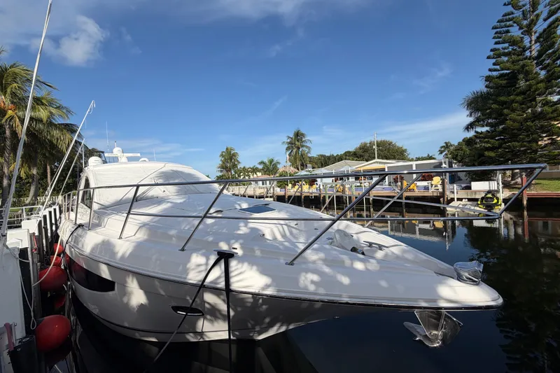 Slide: The Image of 2018 Regal 53 Sport Coupe yacht docked by palm trees under clear blue sky. - 22