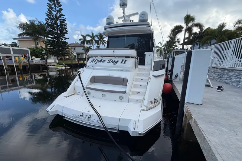 Slide: The Image of 2018 Regal 53 Sport Coupe yacht docked in a serene marina setting. - 0