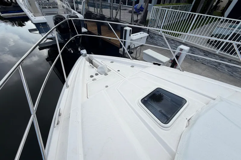 Slide: The Image of 2018 Regal 53 Sport Coupe yacht docked, showcasing sleek deck design and railing. - 42