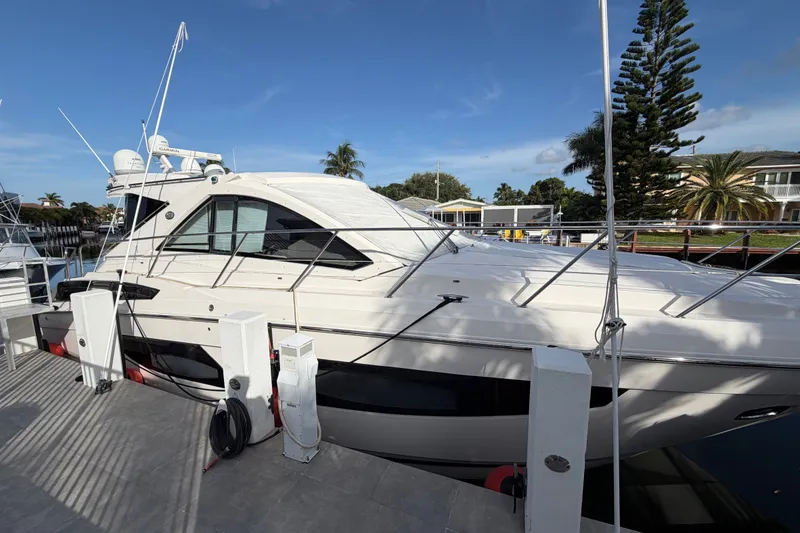 Slide: The Image of 2018 Regal 53 Sport Coupe yacht docked at marina under clear blue sky. - 7