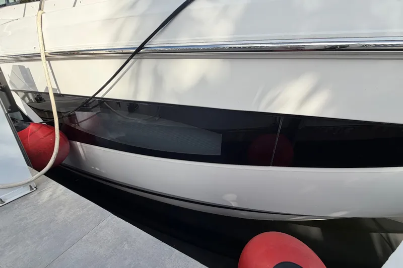 Slide: The Image of 2018 Regal 53 Sport Coupe yacht docked with red fenders and mooring lines. - 23