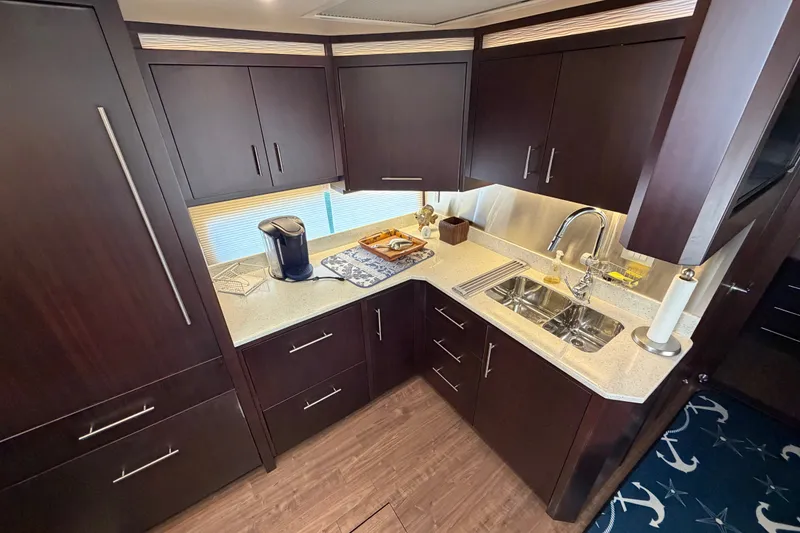 Slide: The Image of Luxurious kitchen interior of 2018 Regal 53 Sport Coupe yacht with dark wood cabinetry. - 92