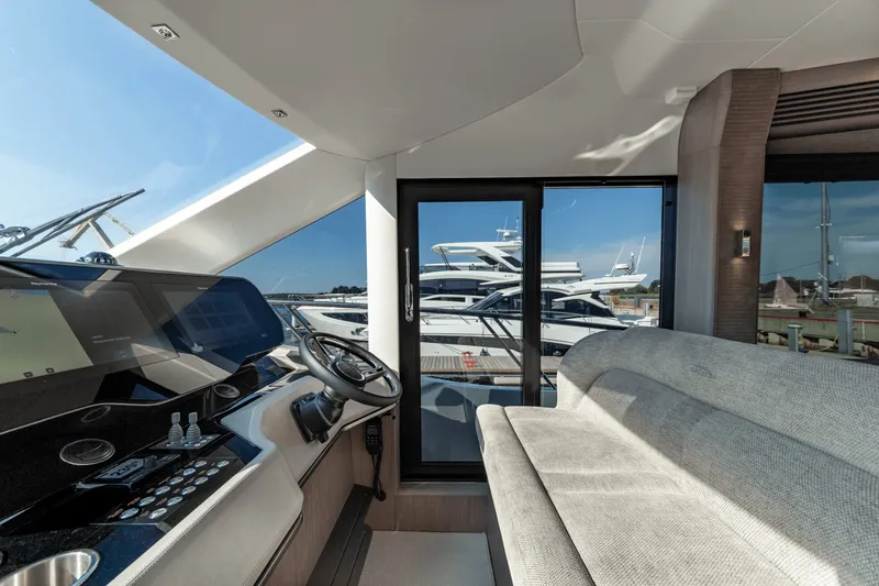 Slide: The Image of Interior of the 2026 Galeon 560 Fly with a modern helm and gray sofa. - 27