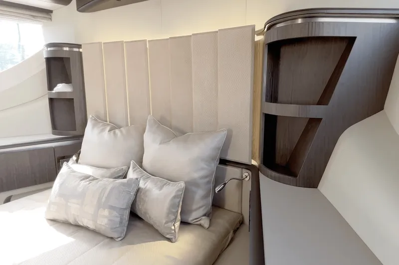 Slide: The Image of Luxurious bedroom with elegant pillows and modern wood accents aboard the Galeon 560 Fly. - 48