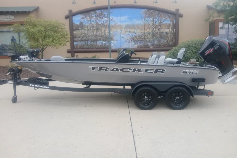 The Image of 2027 Tracker Savage 215 boat on trailer, parked outdoors with scenic mural background. - 0
