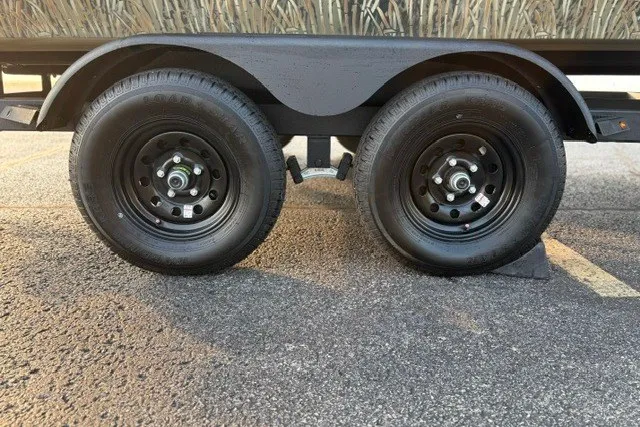 Slide: The Image of Trailer wheels of a 2027 Tracker Grizzly 2072 CC on asphalt pavement. - 19