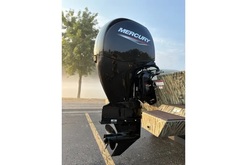 Slide: The Image of Mercury outboard motor on 2027 Tracker Grizzly 2072 CC boat, parked outdoors. - 13