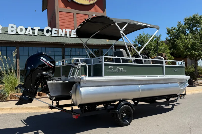 Slide: The Image of 2027 Sun Tracker Bass Buggy 18 DLX pontoon boat on trailer outside dealership. - 14