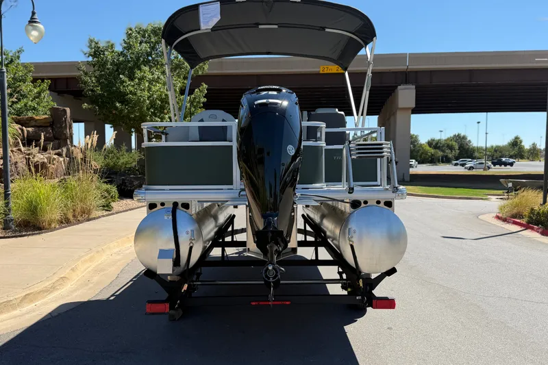 Slide: The Image of 2027 Sun Tracker Bass Buggy 18 DLX pontoon boat on trailer, parked outdoors. - 13