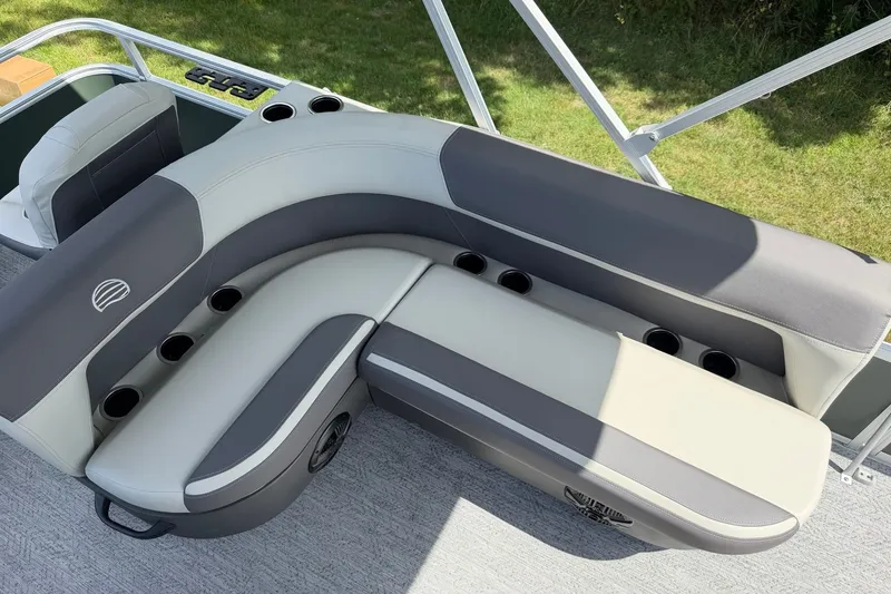 Slide: The Image of 2027 Sun Tracker Bass Buggy 18 DLX pontoon boat seating with cup holders, gray and white upholstery. - 20