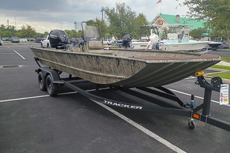 The Image of 2027 Tracker Grizzly 2072 CC boat on trailer in parking lot, camo design. - 0