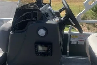 Slide: The Image of 2027 Sun Tracker Bass Buggy 18 DLX boat console with steering wheel and controls. - 15