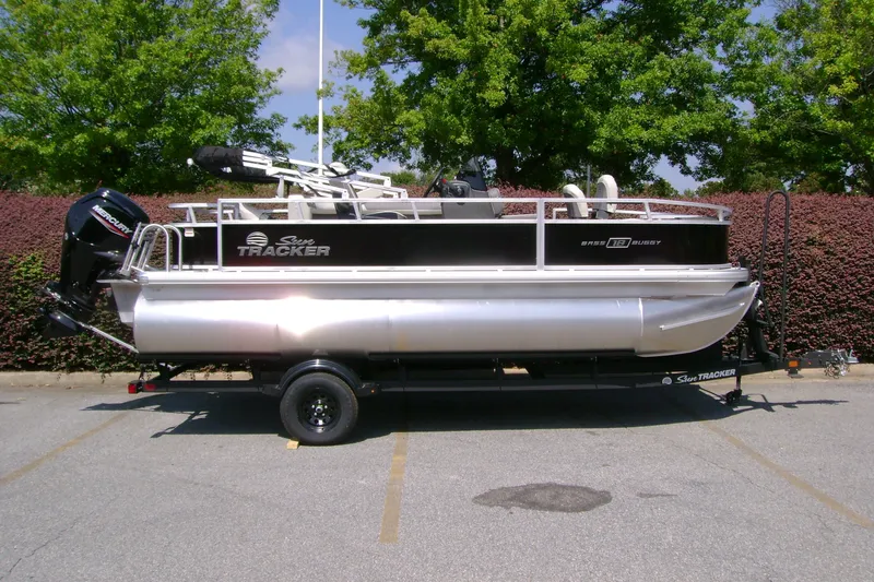 The Image of 2027 Sun Tracker Bass Buggy 18 DLX pontoon boat on trailer, parked outdoors. - 0