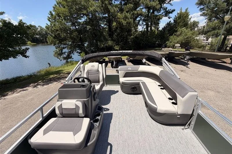Slide: The Image of 2027 Sun Tracker Bass Buggy 16 XL Select pontoon boat with spacious seating and scenic lake view. - 13