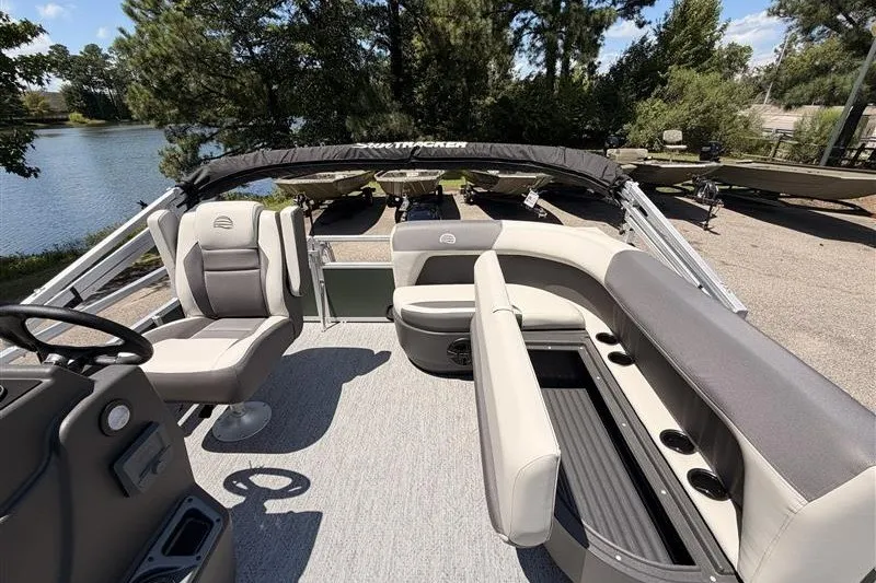 Slide: The Image of 2027 Sun Tracker Bass Buggy 16 XL Select pontoon boat interior with seating and steering wheel. - 16