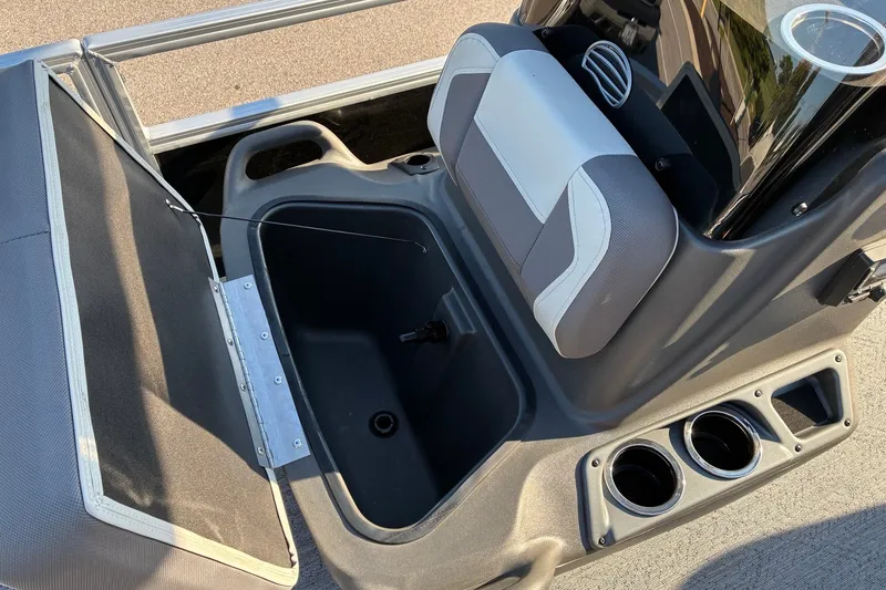 Slide: The Image of 2027 Sun Tracker Bass Buggy 18 DLX interior with storage compartment and cup holders. - 14