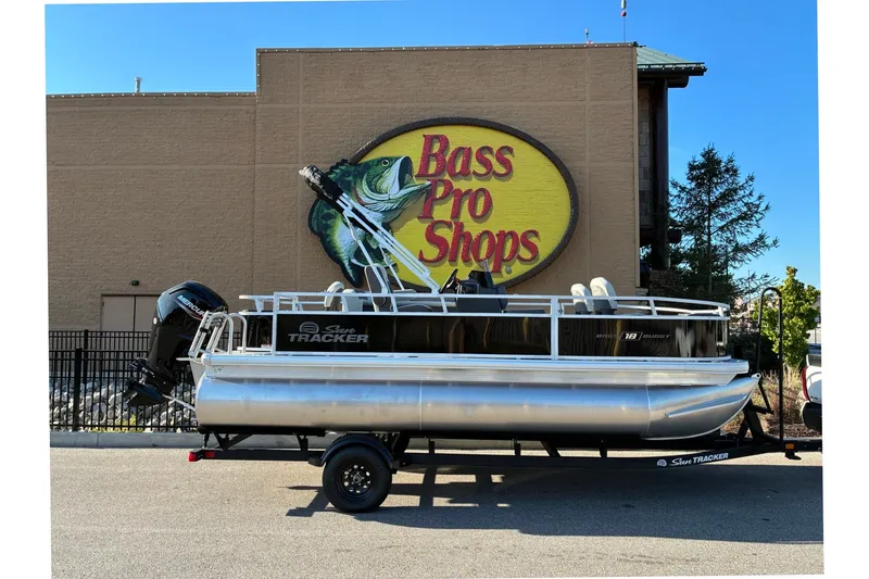 The Image of 2027 Sun Tracker Bass Buggy 18 DLX pontoon boat outside Bass Pro Shops. - 0