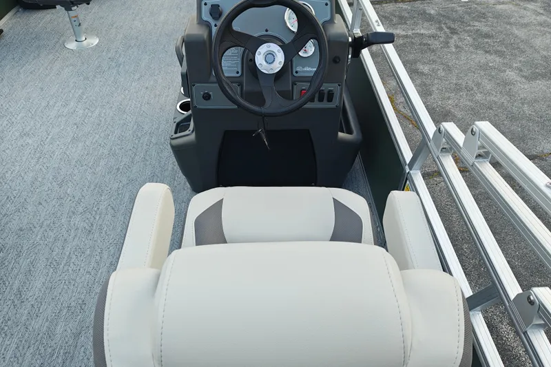Slide: The Image of 2027 Sun Tracker Bass Buggy 18 DLX boat interior with steering wheel and seating. - 22