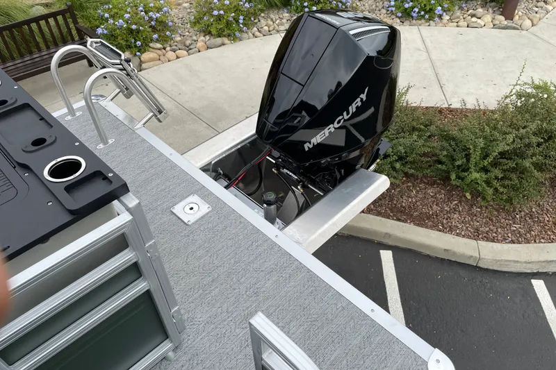 Slide: The Image of 2027 Sun Tracker Fishin' Barge 22 XP3 with Mercury outboard motor, parked on pavement. - 15