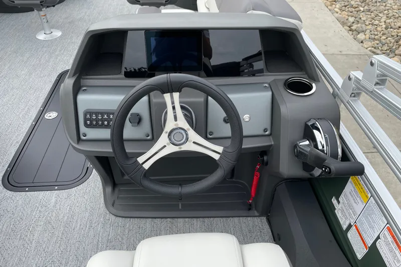 Slide: The Image of Steering console of 2027 Sun Tracker Fishin' Barge 22 XP3 with modern controls and cup holder. - 26
