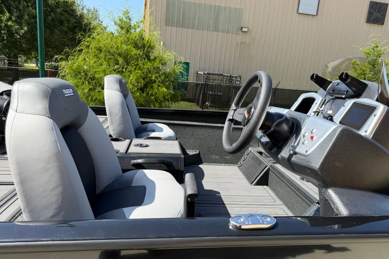 Slide: The Image of 2027 Tracker Savage 215 boat interior with steering wheel and comfortable seating. - 18