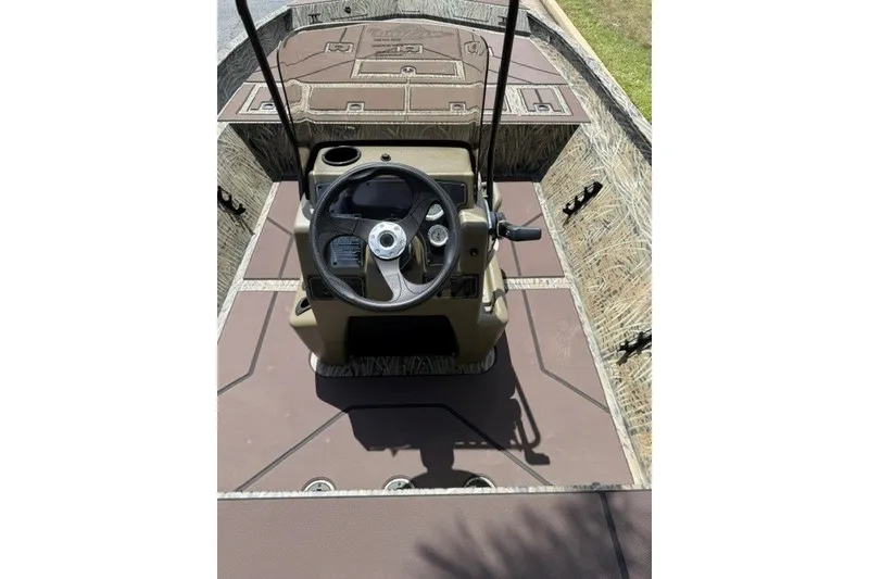 Slide: The Image of 2027 Tracker Grizzly 2072 CC boat interior with steering console and camouflage design. - 16