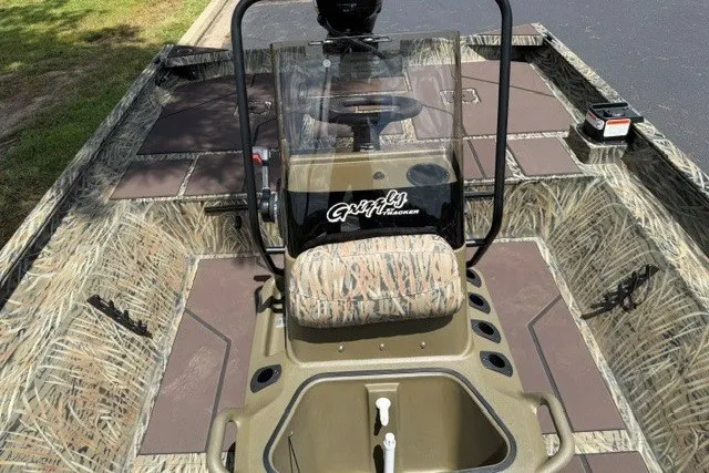 Slide: The Image of 2027 Tracker Grizzly 2072 CC boat interior with camouflage design and central console. - 14