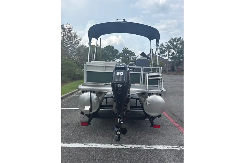 Slide: The Image of 2027 Sun Tracker Bass Buggy 16 XL Select pontoon boat with outboard motor in parking lot. - 14