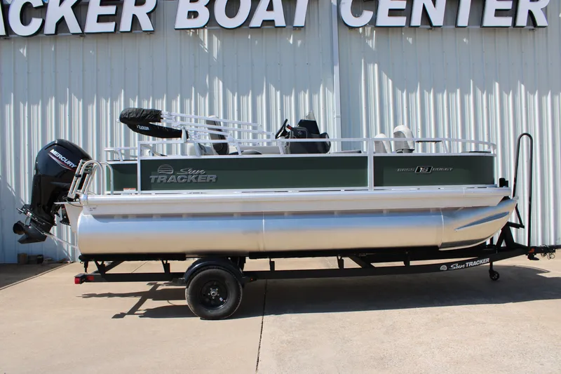 The Image of 2027 Sun Tracker Bass Buggy 18 DLX pontoon boat on trailer at dealership. - 0