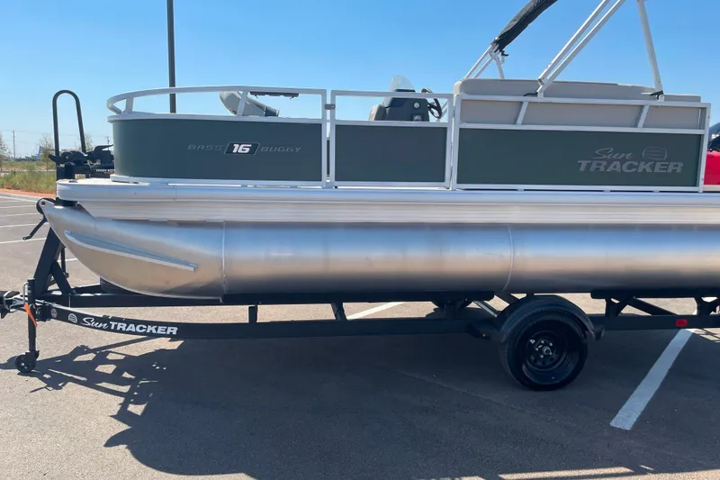 The Image of 2027 Sun Tracker Bass Buggy 16 XL Select pontoon boat on trailer in parking lot. - 0