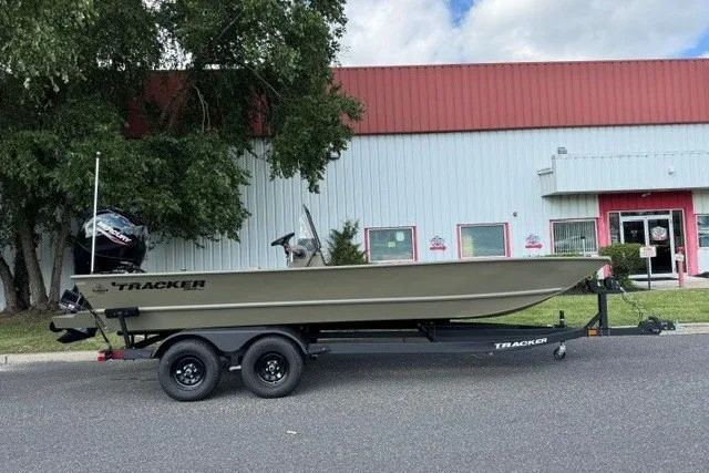 The Image of 2027 Tracker Grizzly 2072 CC boat on trailer, parked outside a building. - 0
